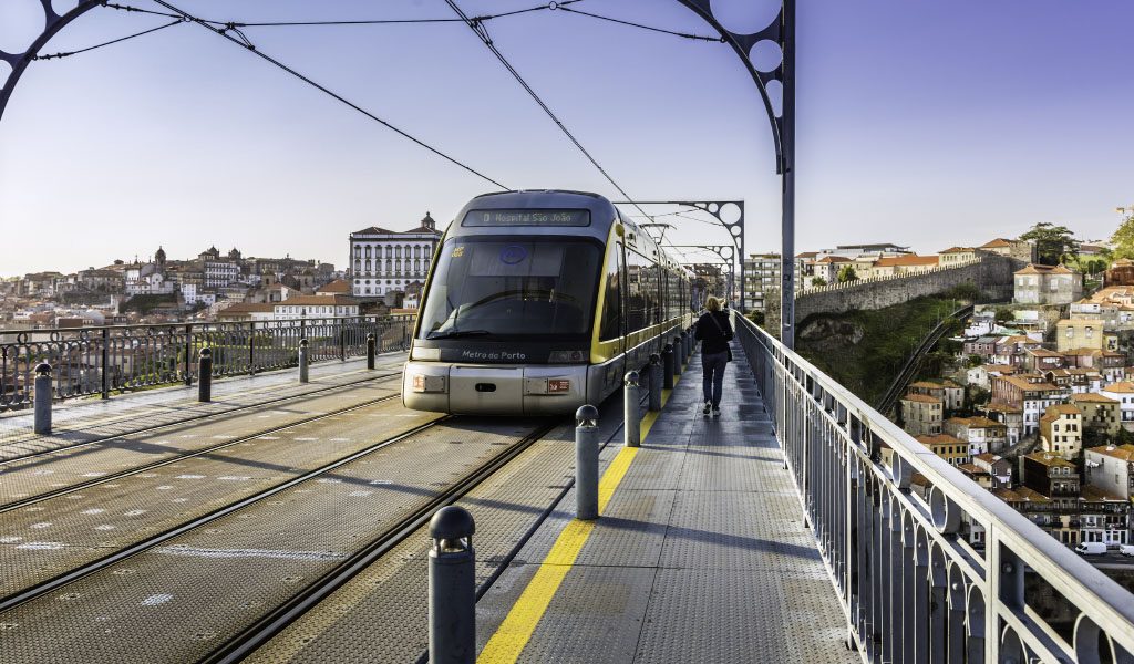 Porto, Portugal - May 22, 2016: Metro rail seen from the front travelling over the Dom Luis I bridge that lies over river Douro in Porto city. This is a popular tourist destination declared a UNESCO world heritage site. The cityscape seen on either side of the bridge.